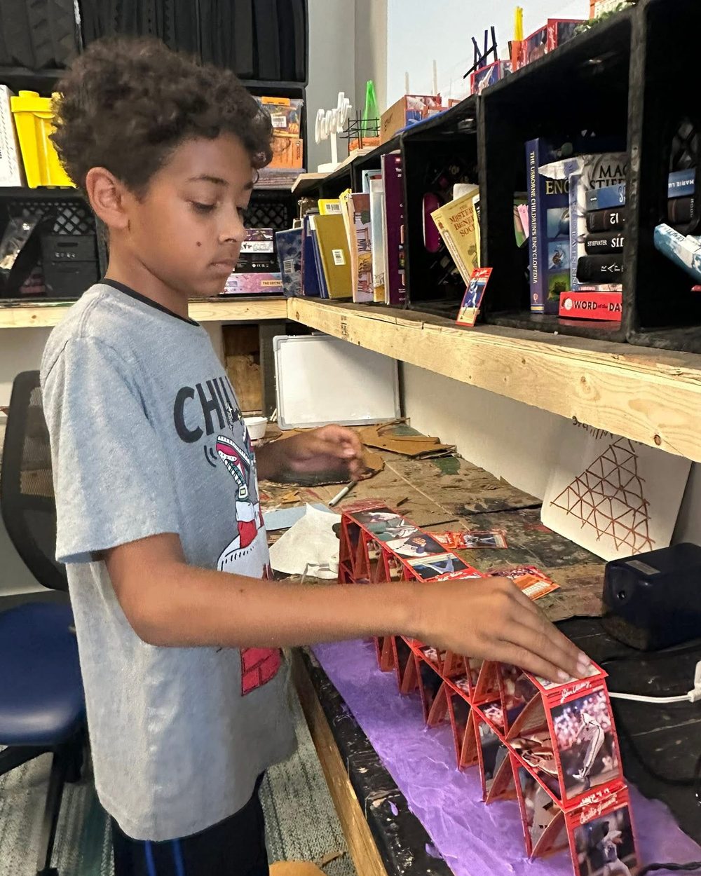A TriPoint student concentrating on assembling a paper craft project.
